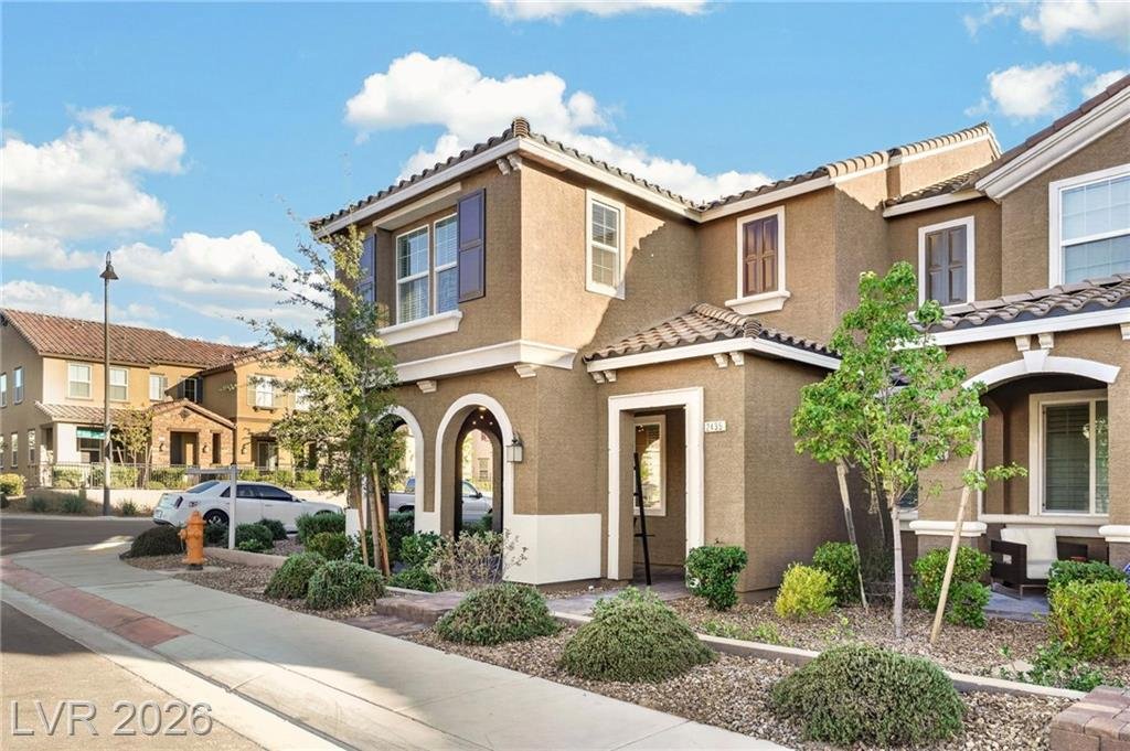 Corner lot view of 2435 Bellinzona Place showing the arched entry and extra windows