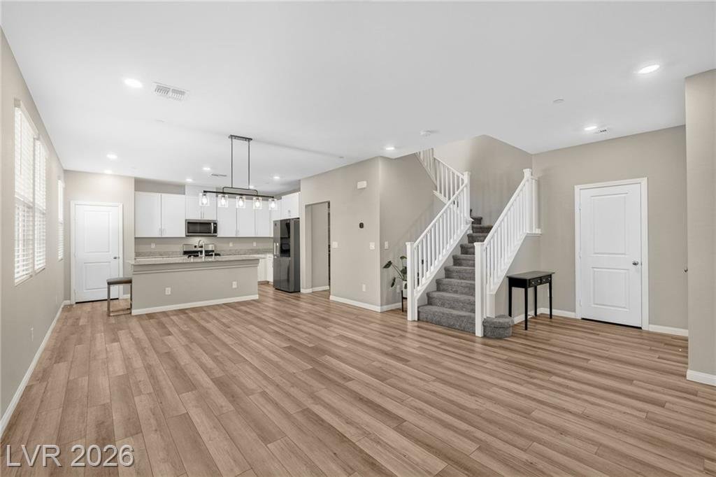 Open great room with luxury vinyl plank flooring looking toward the kitchen