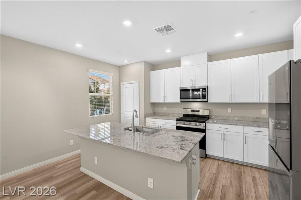 Kitchen island with granite counters and white shaker cabinetry
