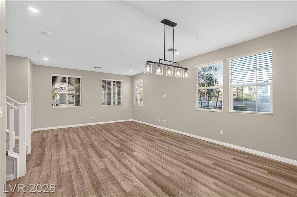 Dining area with black linear chandelier and corner-lot windows
