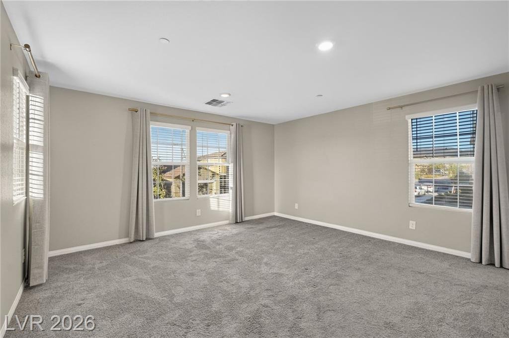 Primary bedroom with two windows and full-length curtains