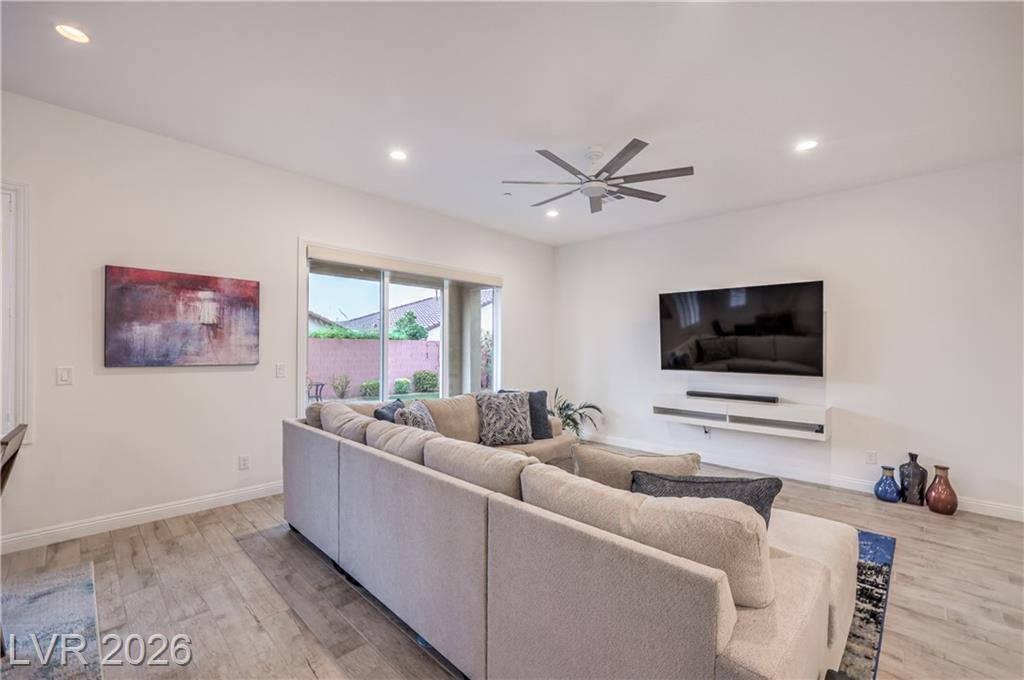 Family room with ceiling fan and mounted television