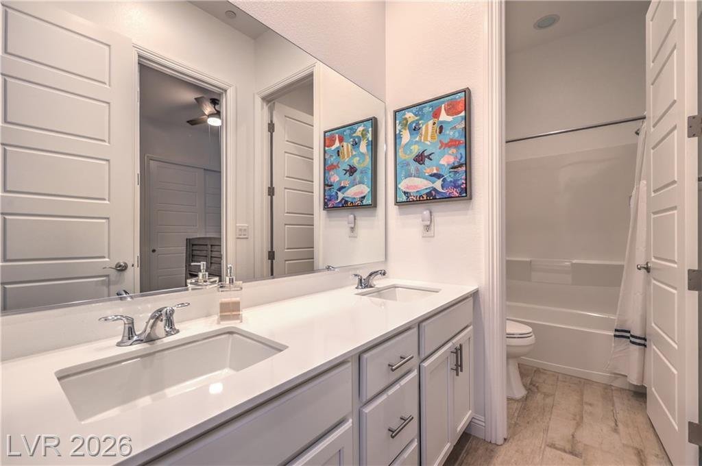 Jack and Jill bathroom with dual sinks and tub shower