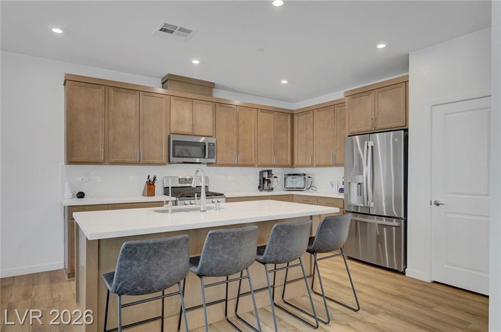 Kitchen with oversized island, quartz countertops and stainless steel appliances