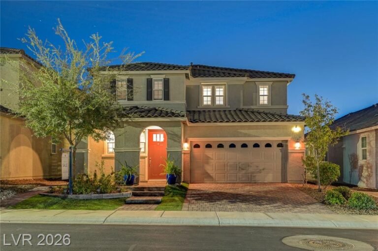 Front exterior of 2587 Tolmezzo Street at twilight with a red front door and two-car garage