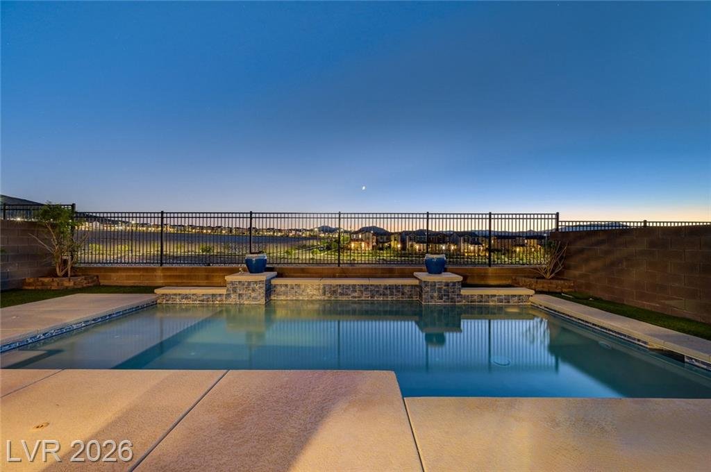 Pool deck at 2587 Tolmezzo Street facing the mountains through a wrought-iron fence