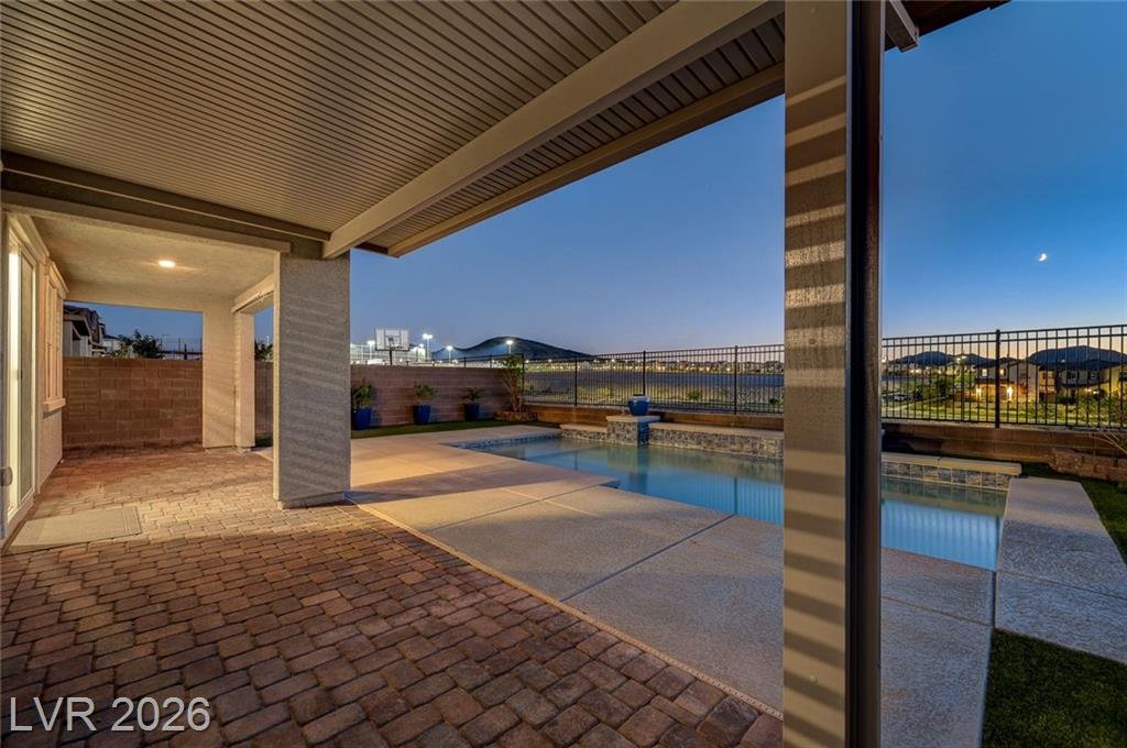 Covered patio at 2587 Tolmezzo Street opening onto the pool at dusk