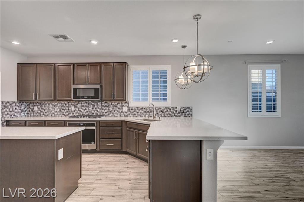 Espresso cabinetry, mosaic backsplash and garden window in the kitchen at 2587 Tolmezzo Street