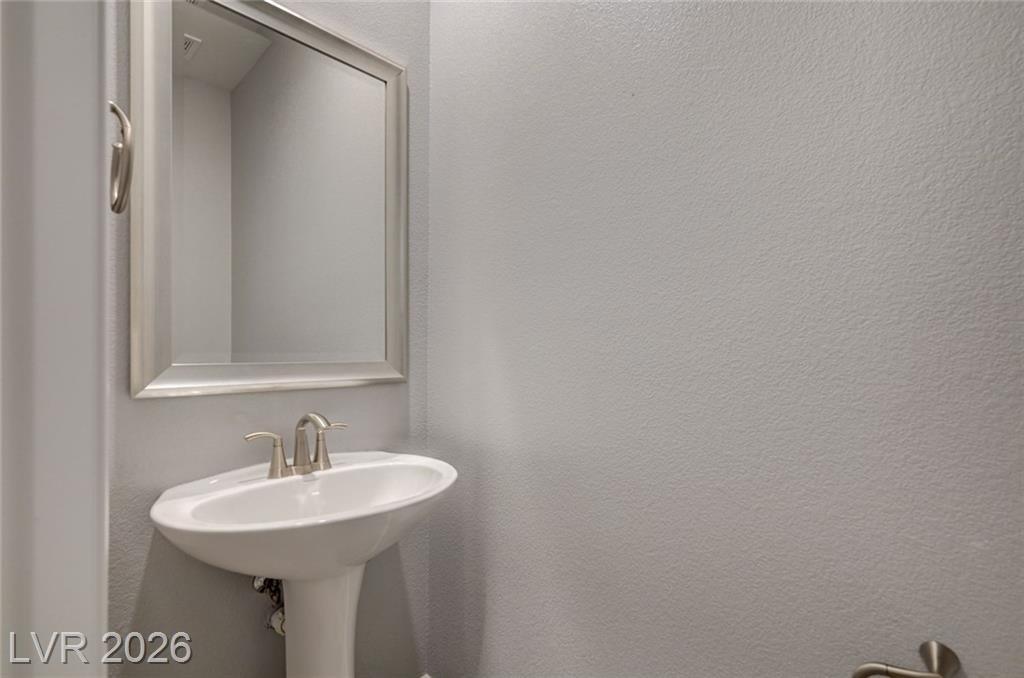 Powder room with a pedestal sink and framed mirror