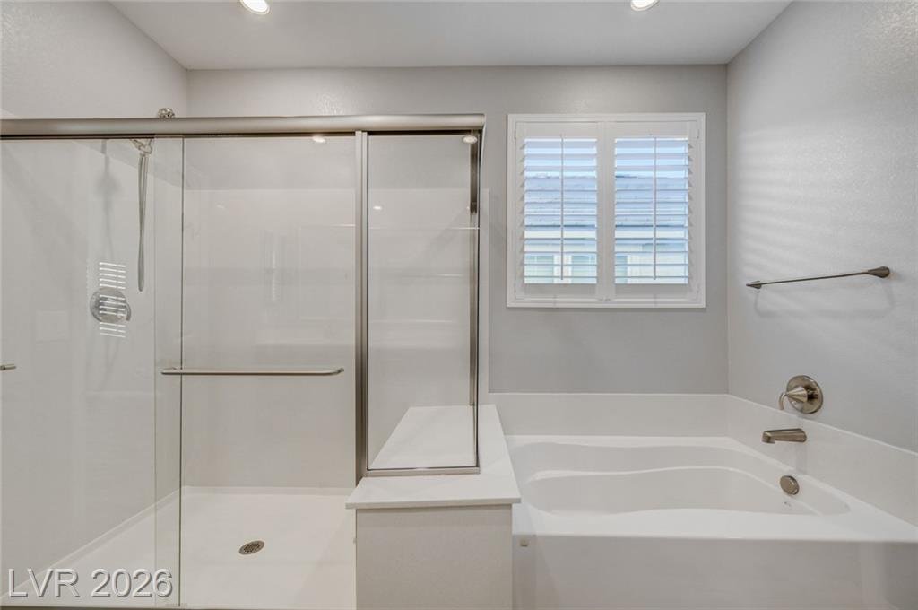 Glass-enclosed shower beside a separate soaking tub at 2587 Tolmezzo Street