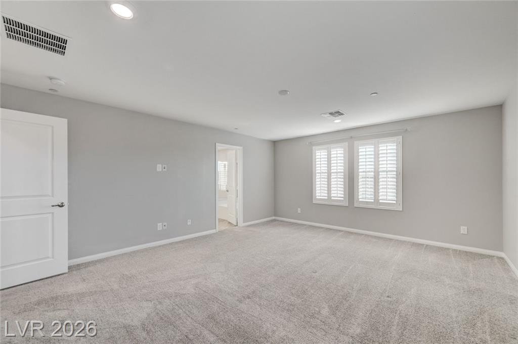 Upstairs primary bedroom with an open door to the bath
