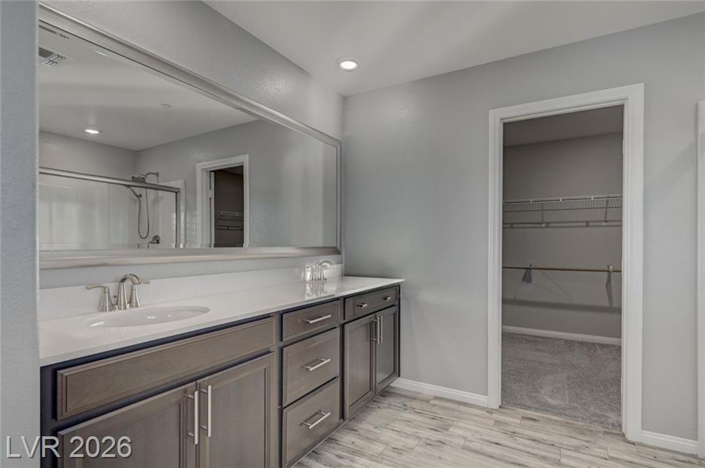 Upstairs primary bath at 2587 Tolmezzo Street with a dual vanity and walk-in closet