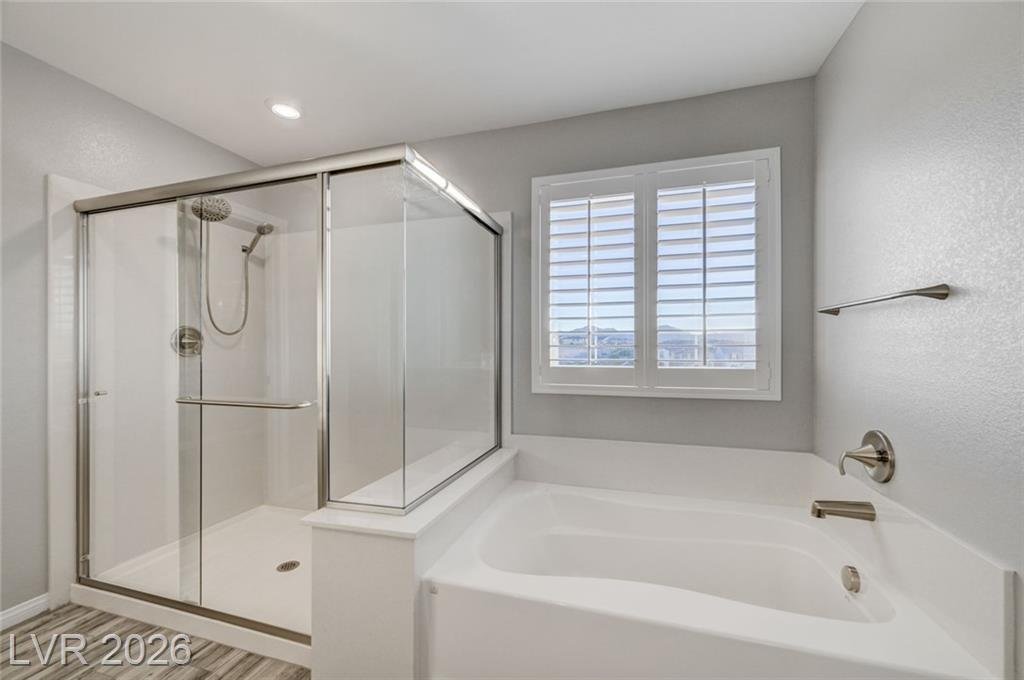 Glass shower and soaking tub in the upstairs primary bath at 2587 Tolmezzo Street