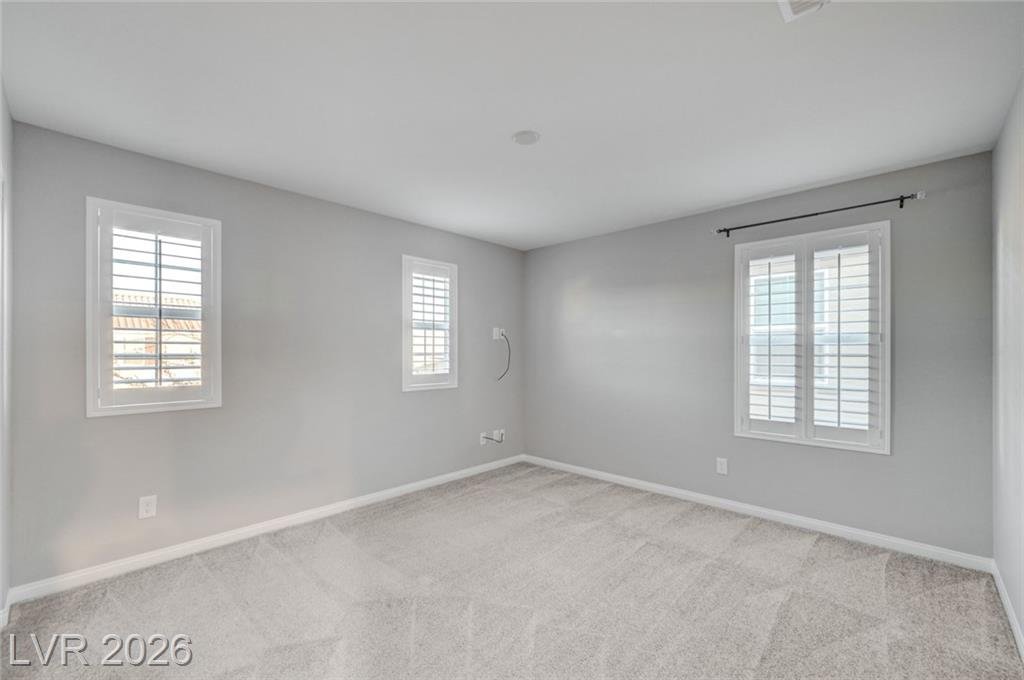 Secondary bedroom with shuttered windows on two walls