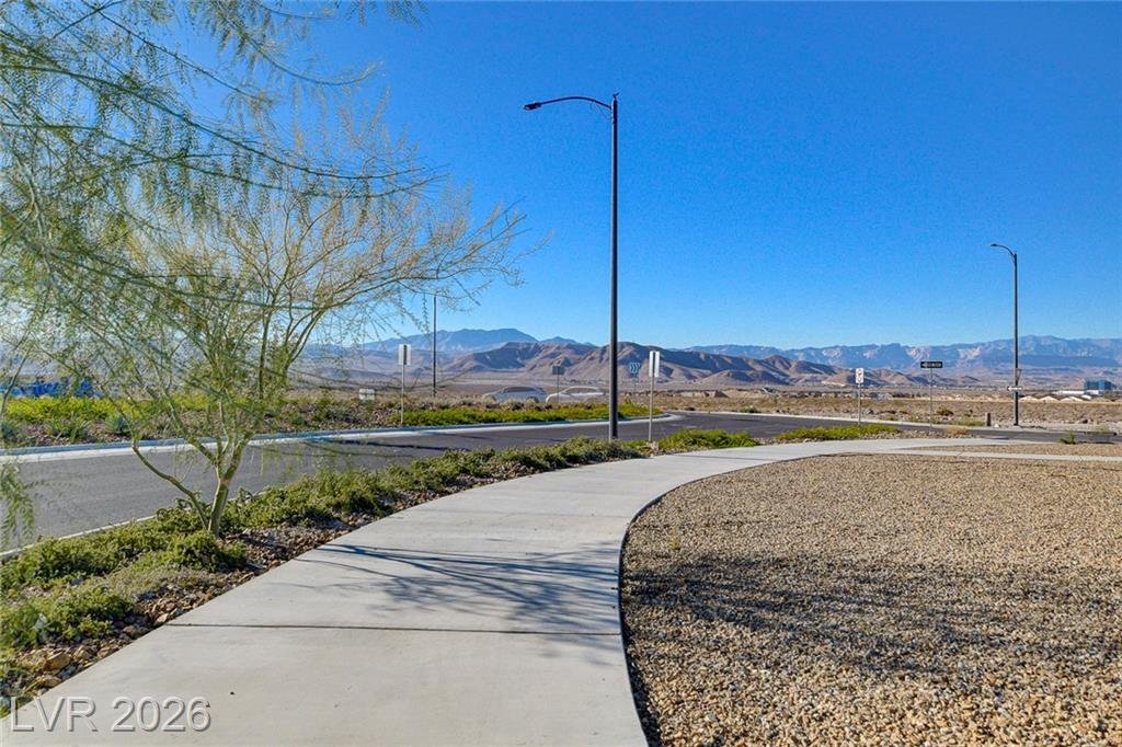 Curving sidewalk with mountain views along a parkway