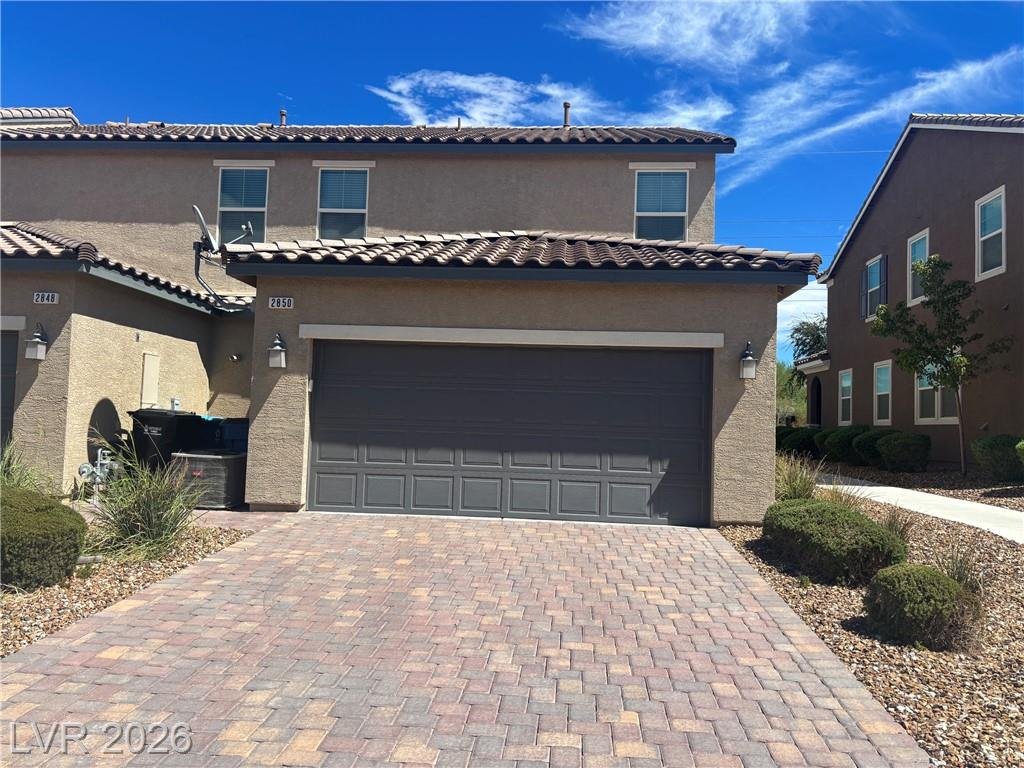 Full-size paver driveway leading to the attached two-car garage