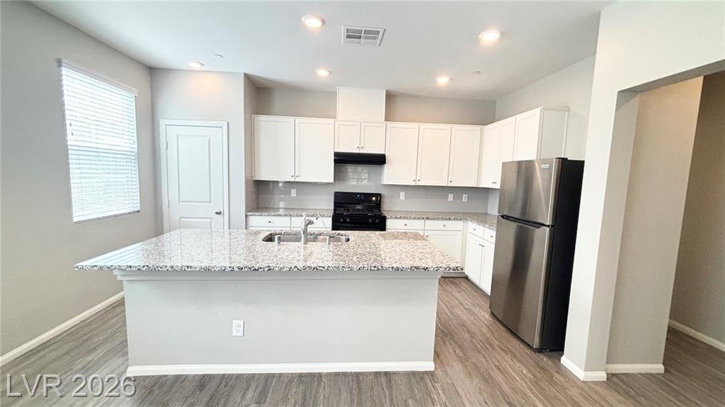 Kitchen island with granite countertops and white upgraded cabinets at 2850 Alenga Street