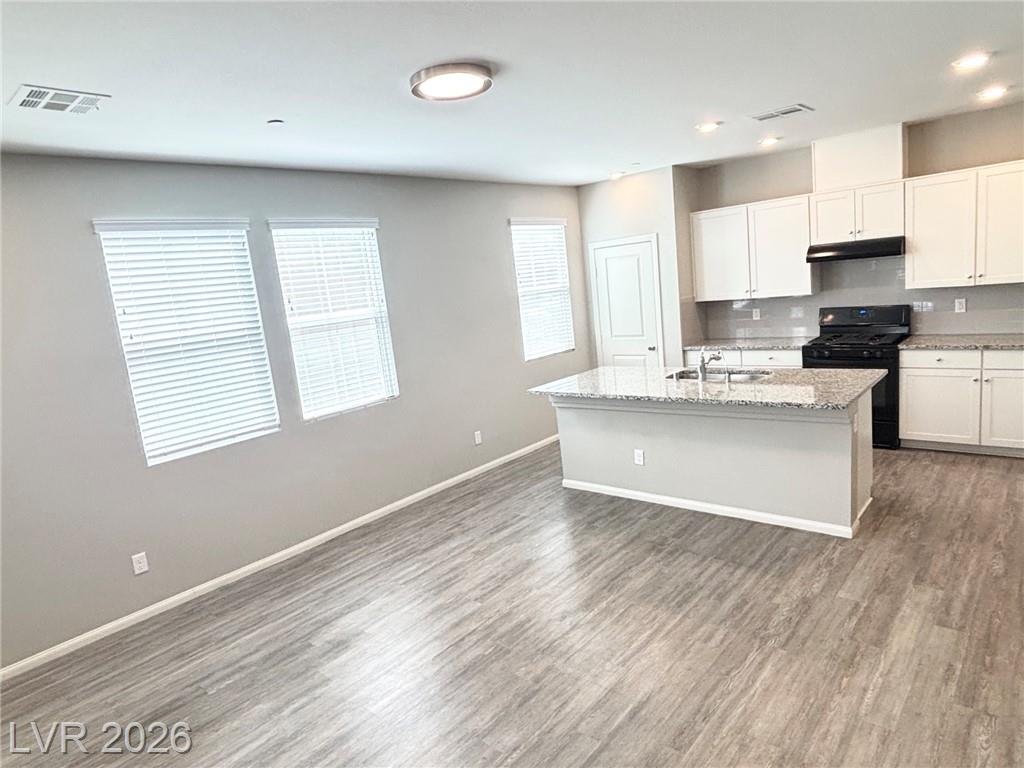 Open kitchen and great room with wood-grain vinyl flooring