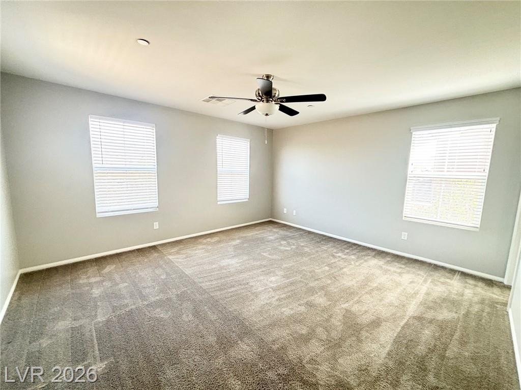 Primary bedroom at 2850 Alenga Street with a ceiling fan and three windows