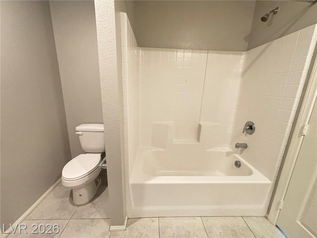 Secondary bathroom with a tub-shower combination and tile floor