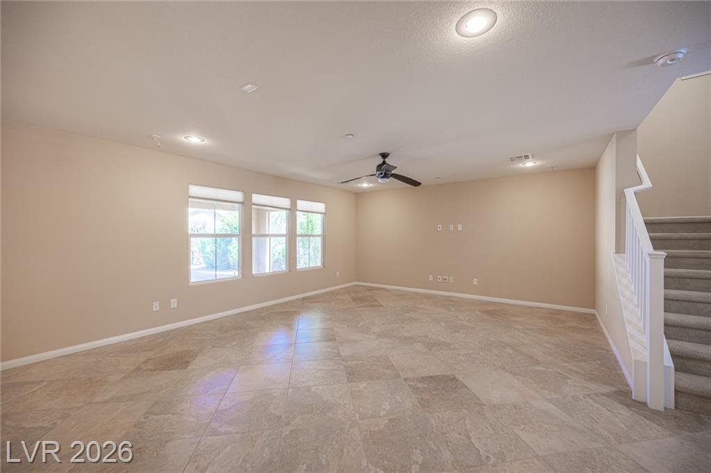 Living room with a ceiling fan and three front windows
