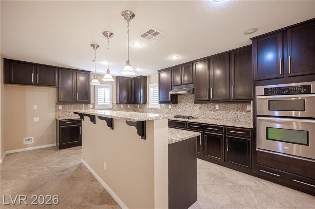 Kitchen island and double wall ovens at 3198 Sisley Garden Avenue