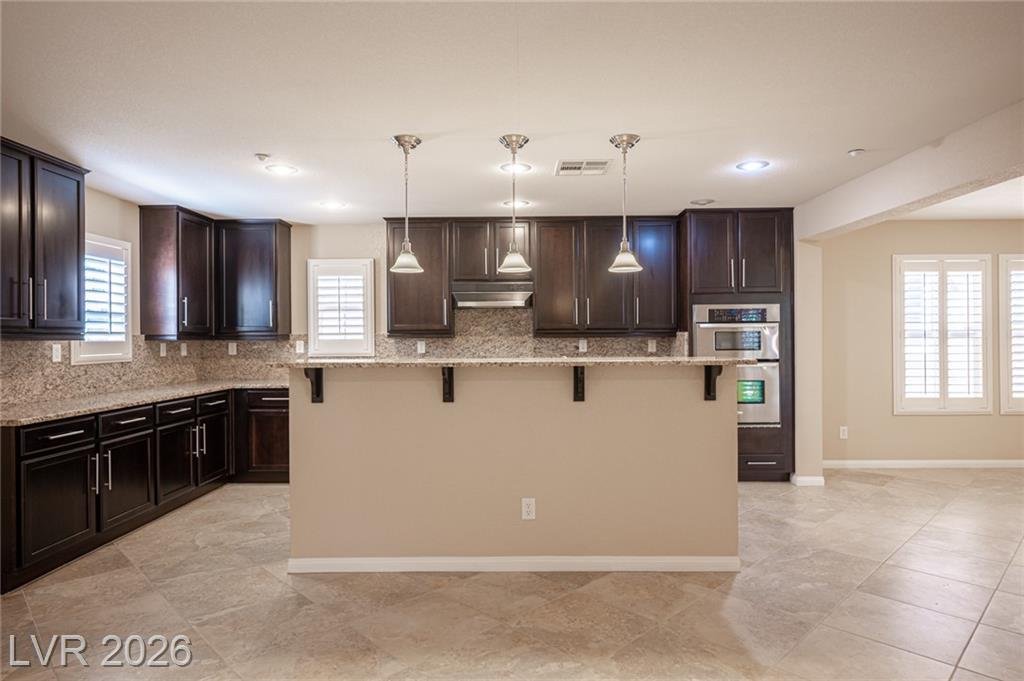Kitchen seen from the dining area with three pendants