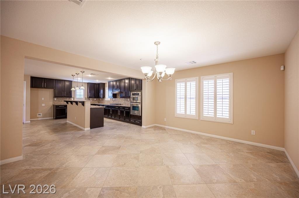 Dining area with a chandelier next to the kitchen