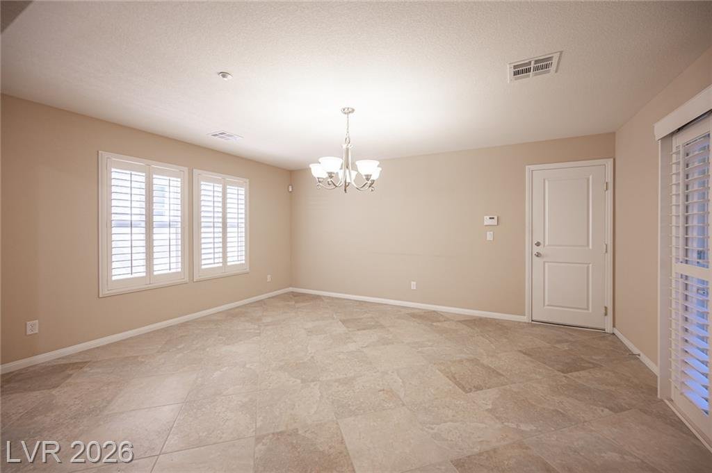 Dining room with plantation shutters and a chandelier