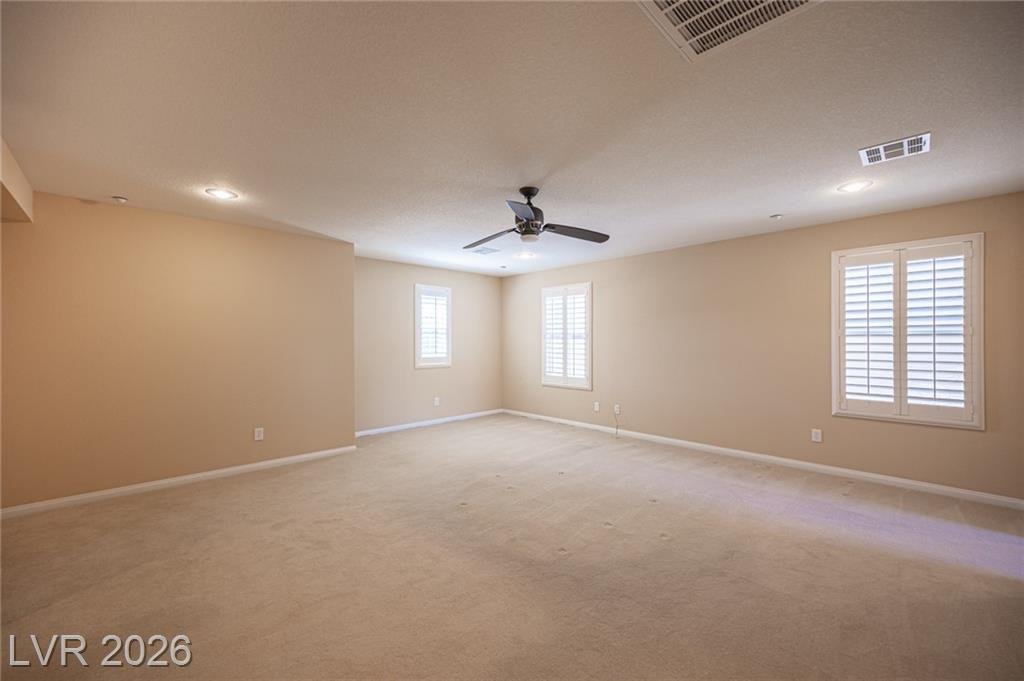 Primary bedroom with a ceiling fan and shutters