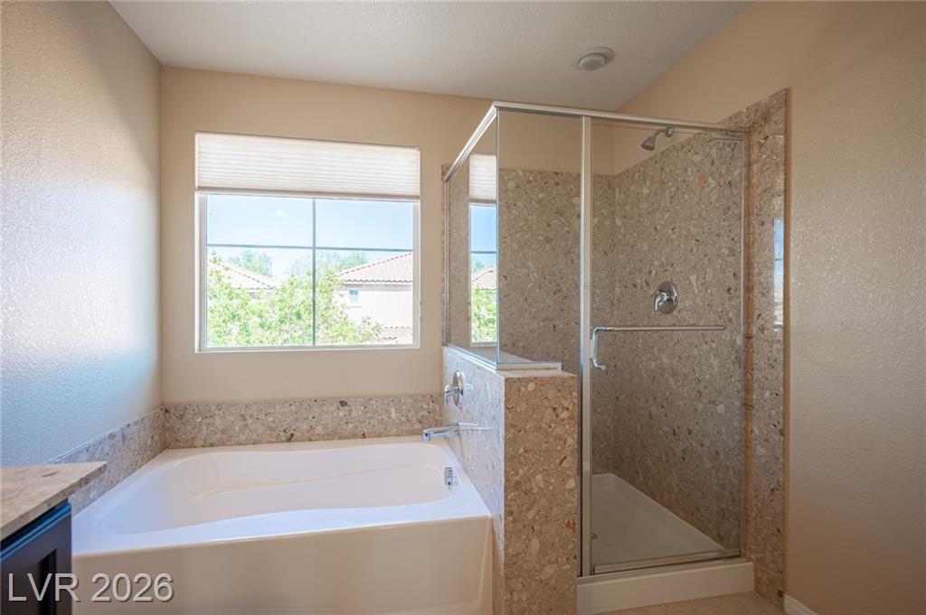Soaking tub beside the glass-enclosed shower