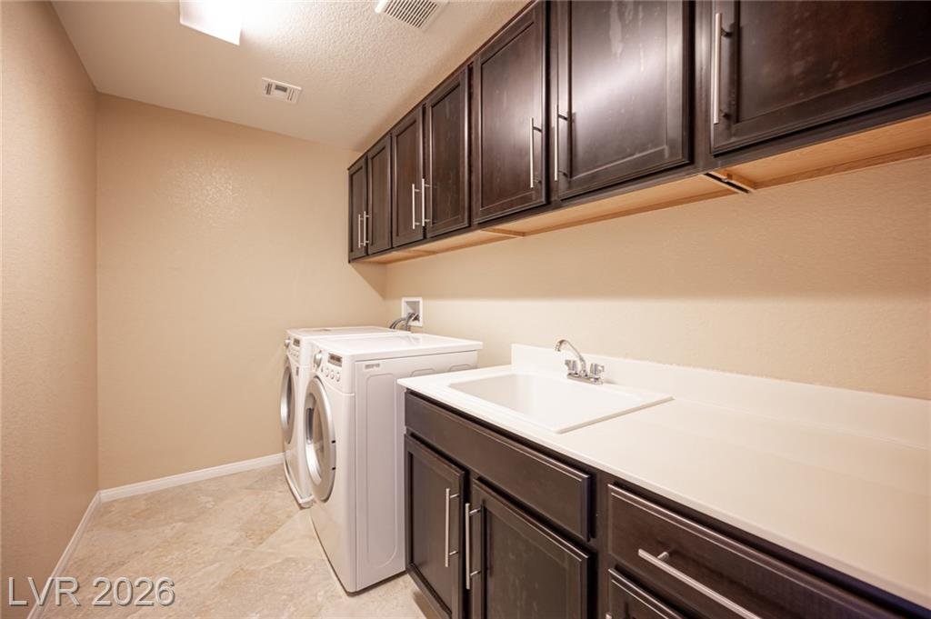 Upstairs laundry room with cabinets and a utility sink