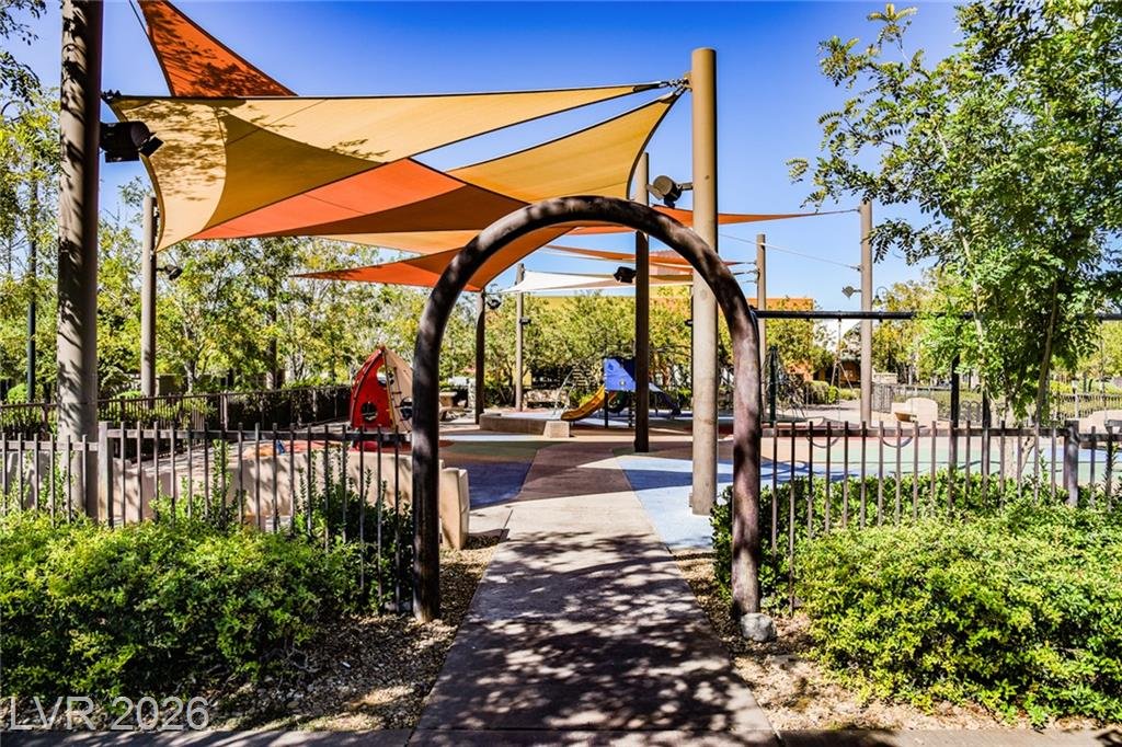 Shaded playground entry with an arched gate
