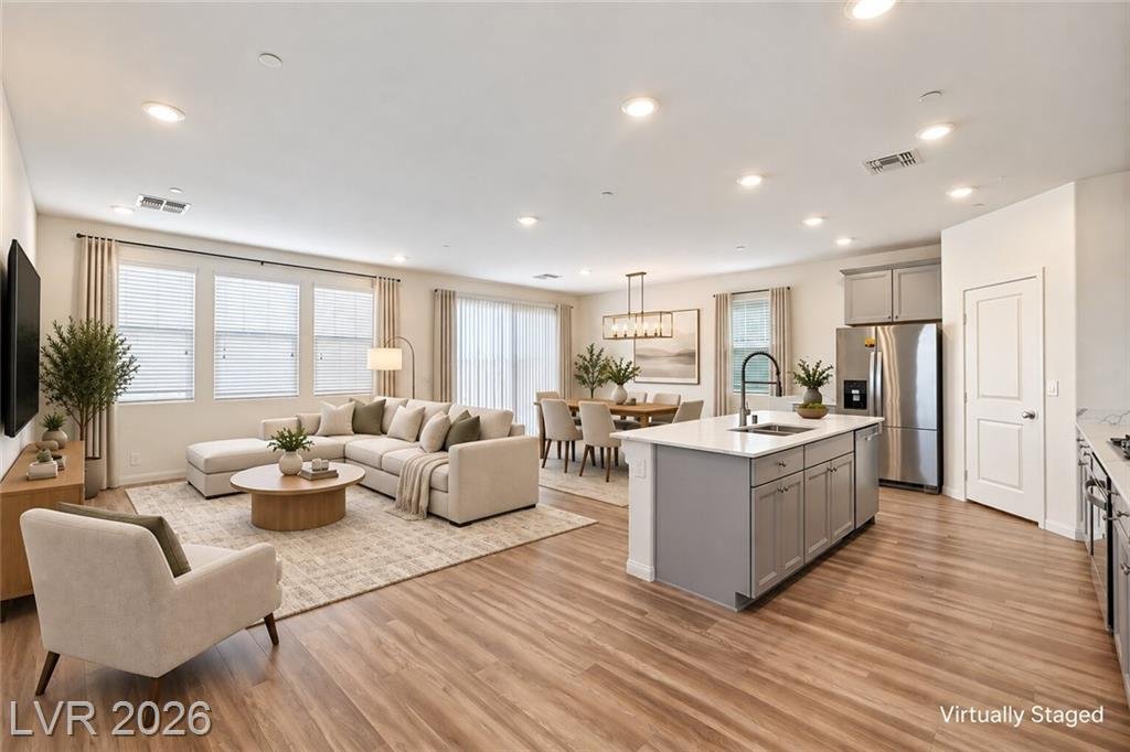 Open great room flowing into the kitchen, virtually staged