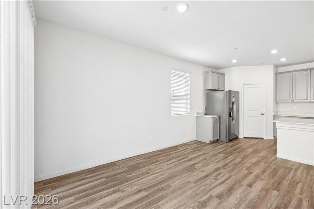 Great room toward the stainless refrigerator and kitchen entry