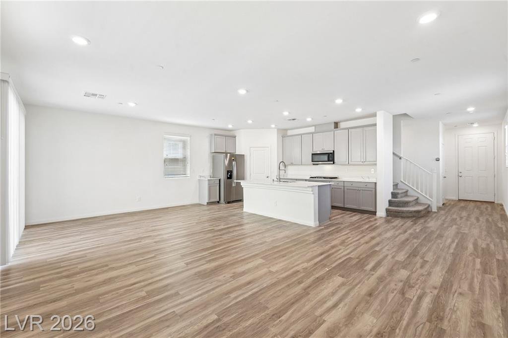 Open floor plan toward the kitchen and carpeted staircase at 3212 Segesta Avenue