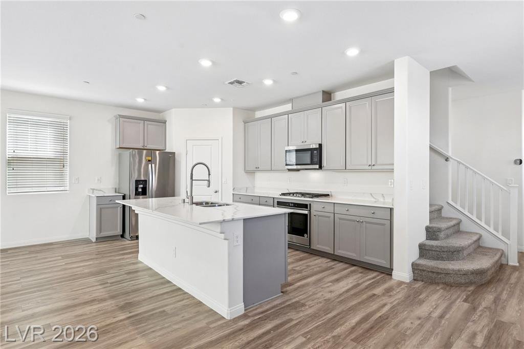 Kitchen island beside the staircase with gray shaker cabinets