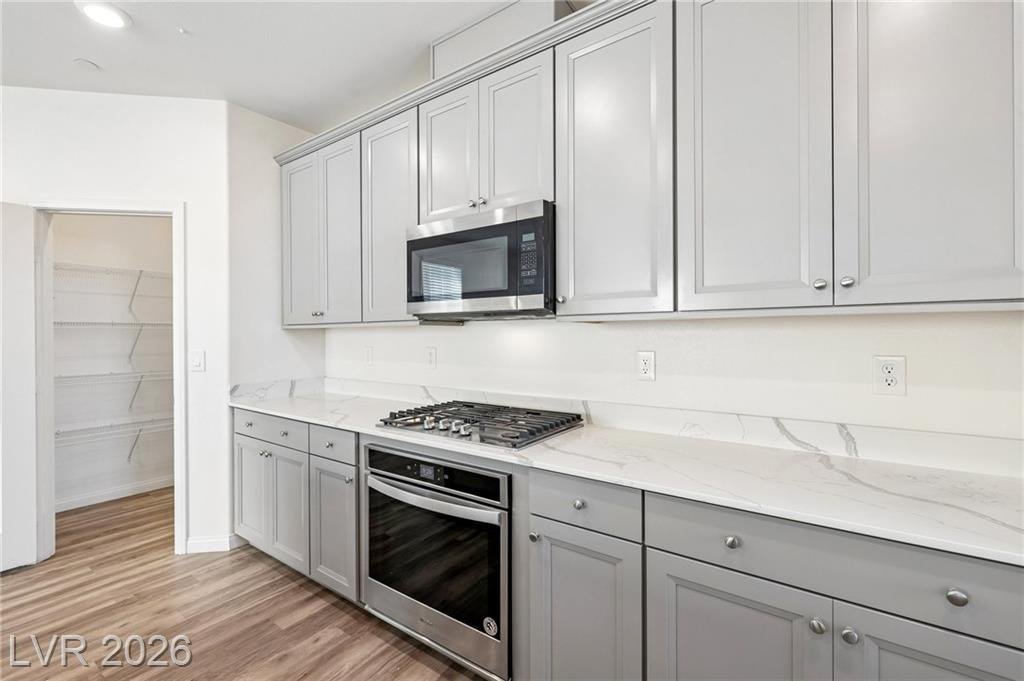 Gas cooktop, built-in oven and microwave with the pantry door open