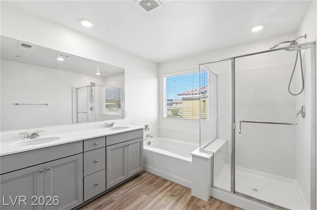 Primary bath dual vanity with gray cabinets at 3212 Segesta Avenue