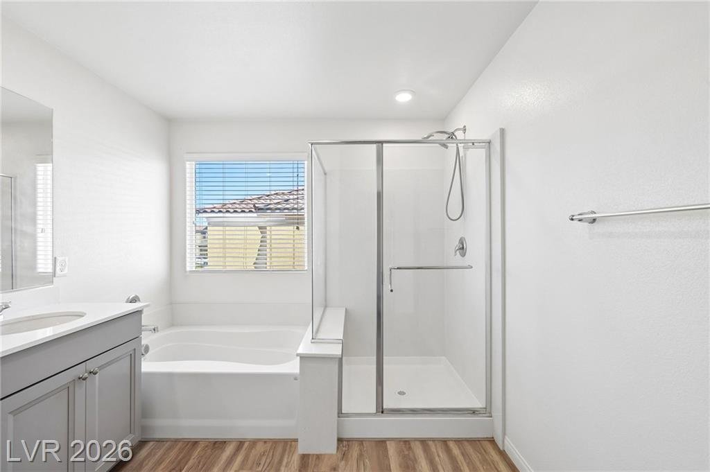 Primary bath soaking tub beside a glass walk-in shower