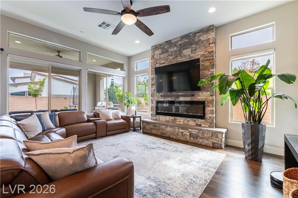 Family room with floor-to-ceiling stacked stone fireplace and leather sectional