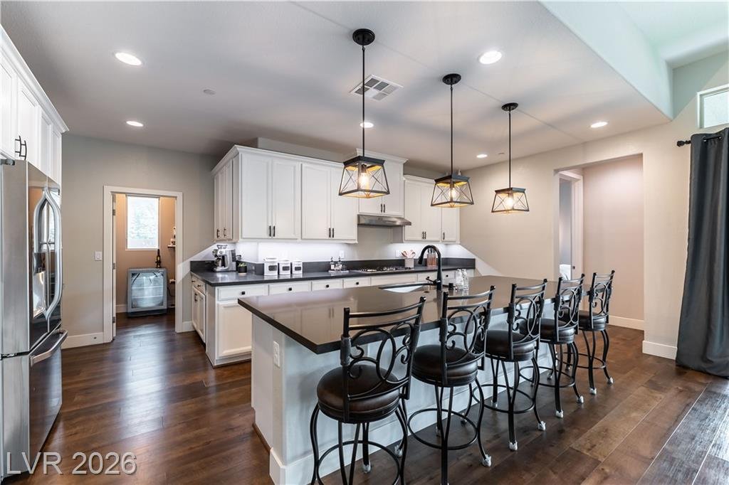 Kitchen island with black pendant lights and dark countertops at 2114 Maderno Street