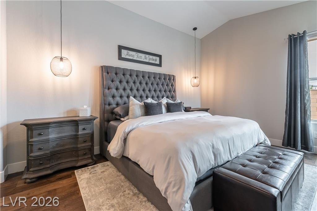 Downstairs primary bedroom with vaulted ceiling and tufted headboard at 2114 Maderno Street