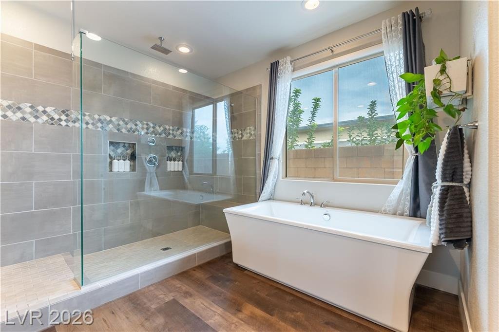 Freestanding soaking tub and tiled walk-in shower in the primary bath at 2114 Maderno Street