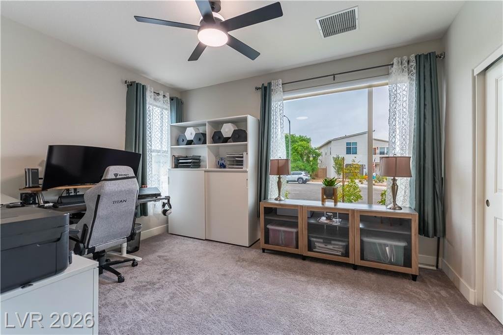 Home office with carpet, ceiling fan and built-in shelving at 2114 Maderno Street