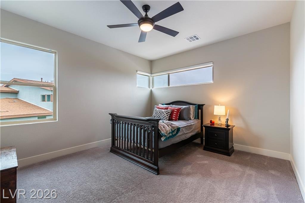 Upstairs bedroom with corner clerestory windows and ceiling fan