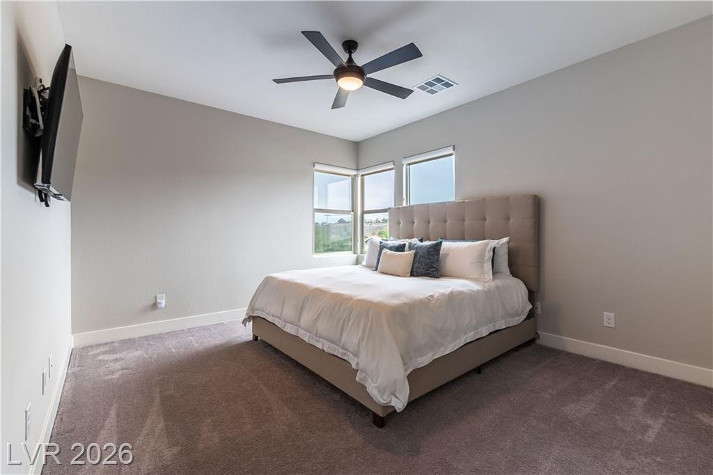 Upstairs bedroom with upholstered bed and corner windows at 2114 Maderno Street