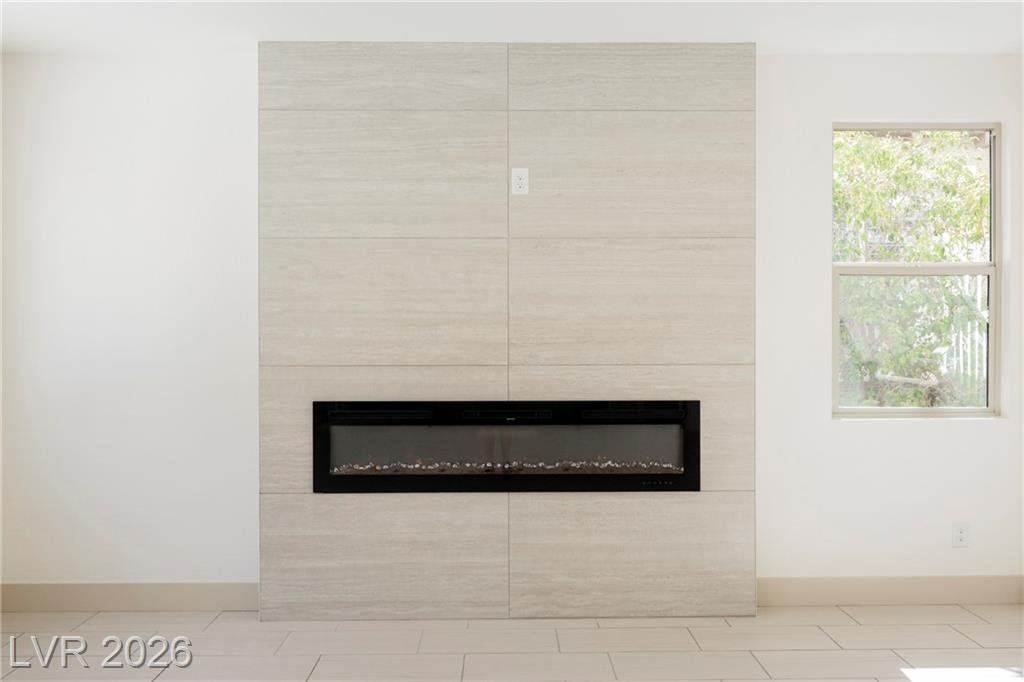 Linear electric fireplace set in a floor-to-ceiling tile surround at 2430 Quiet Ode Street
