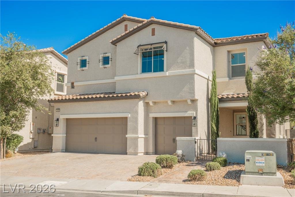 Two-story stucco home with tile roof and three-car garage at 2430 Quiet Ode Street in Inspirada