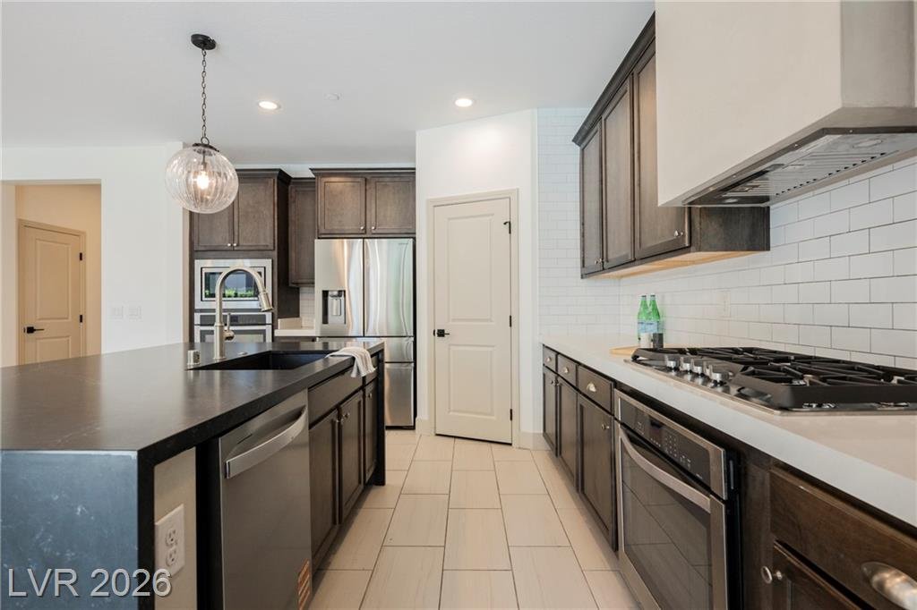 Galley side of the kitchen with five-burner gas cooktop and white subway tile
